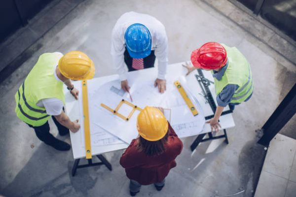 Construction workers and architects working on construction site